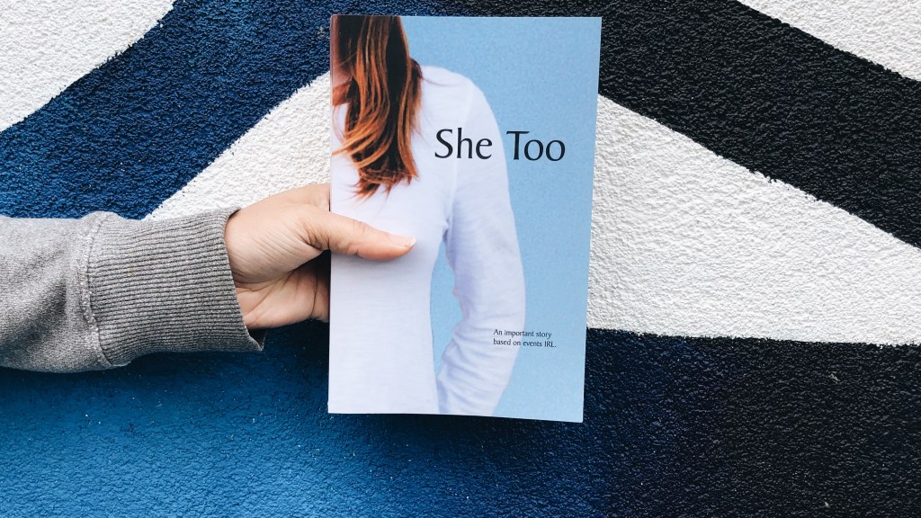 This is an original photograph of a person holding She Too by R. Read, reviewed by Independent Book Review